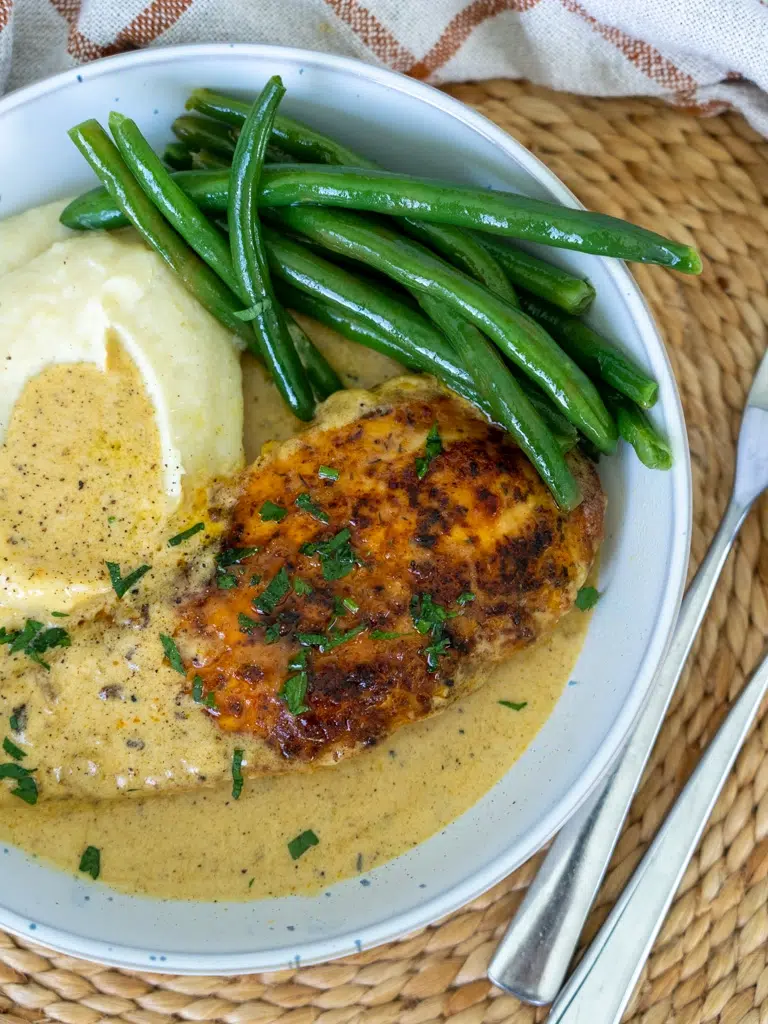 Creamy Garlic Chicken plated with mash potato and green beans