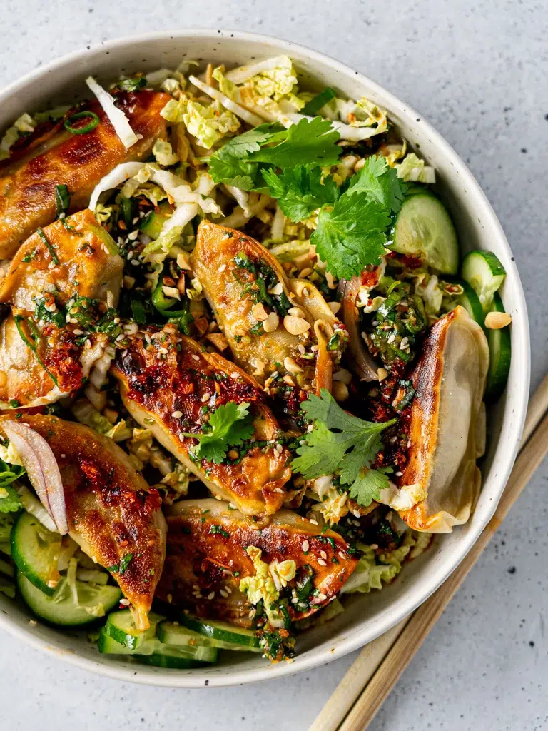 Overhead shot of Sesame-Soy Dumpling Salad featuring dumplings, mixed greens, and colorful veggies.