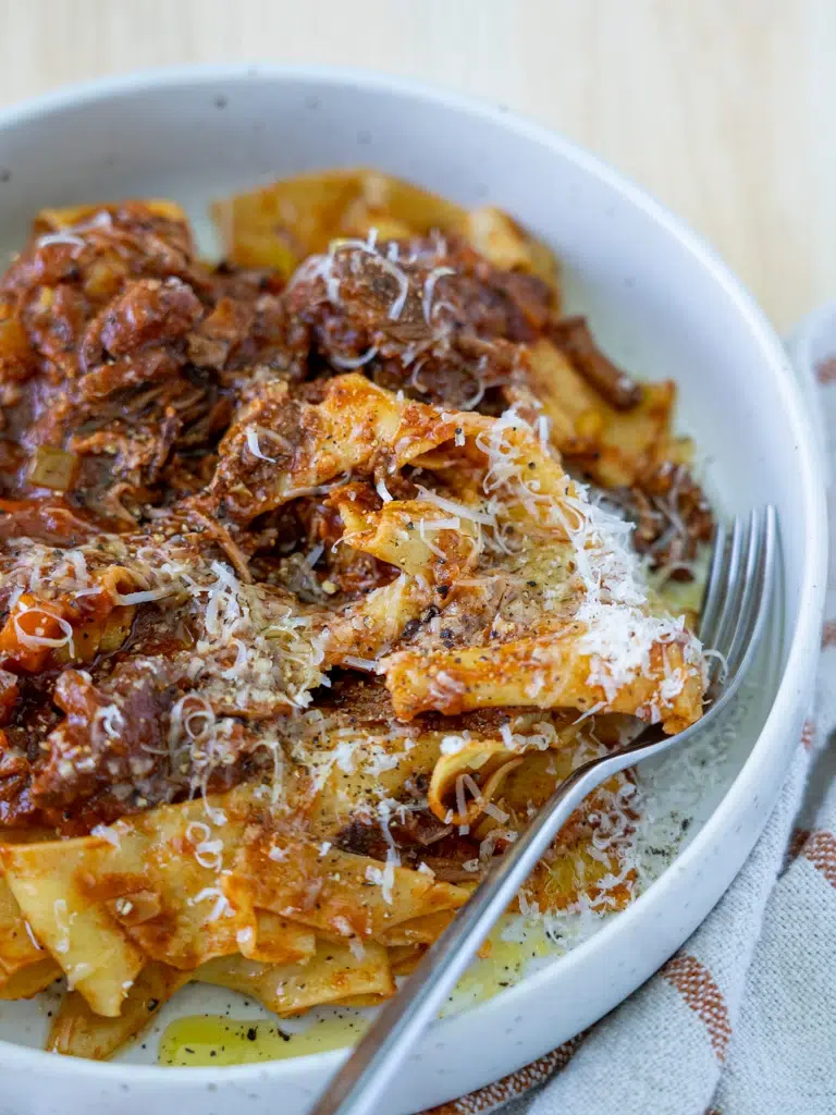 Close-up of slow cooker beef ragu with a fork ready to dig in.